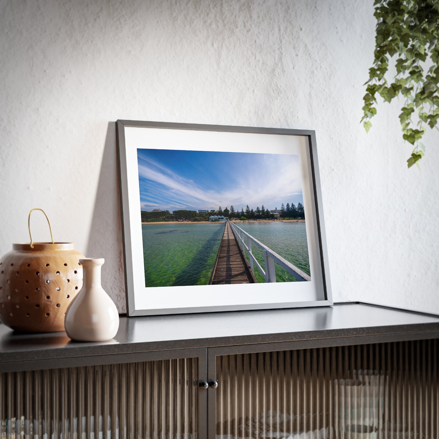 A beautiful jetty leading towards the shore over turquoise waters printed on a matte framed poster