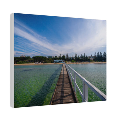 A beautiful jetty leading towards the shore over turquoise waters printed on a stretched matte canvas