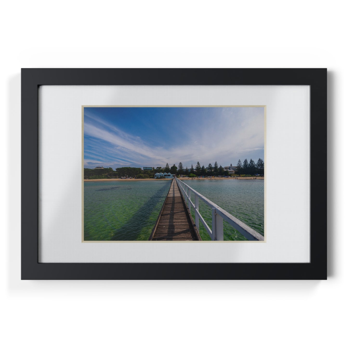 A beautiful jetty leading towards the shore over turquoise waters printed on a black framed poster