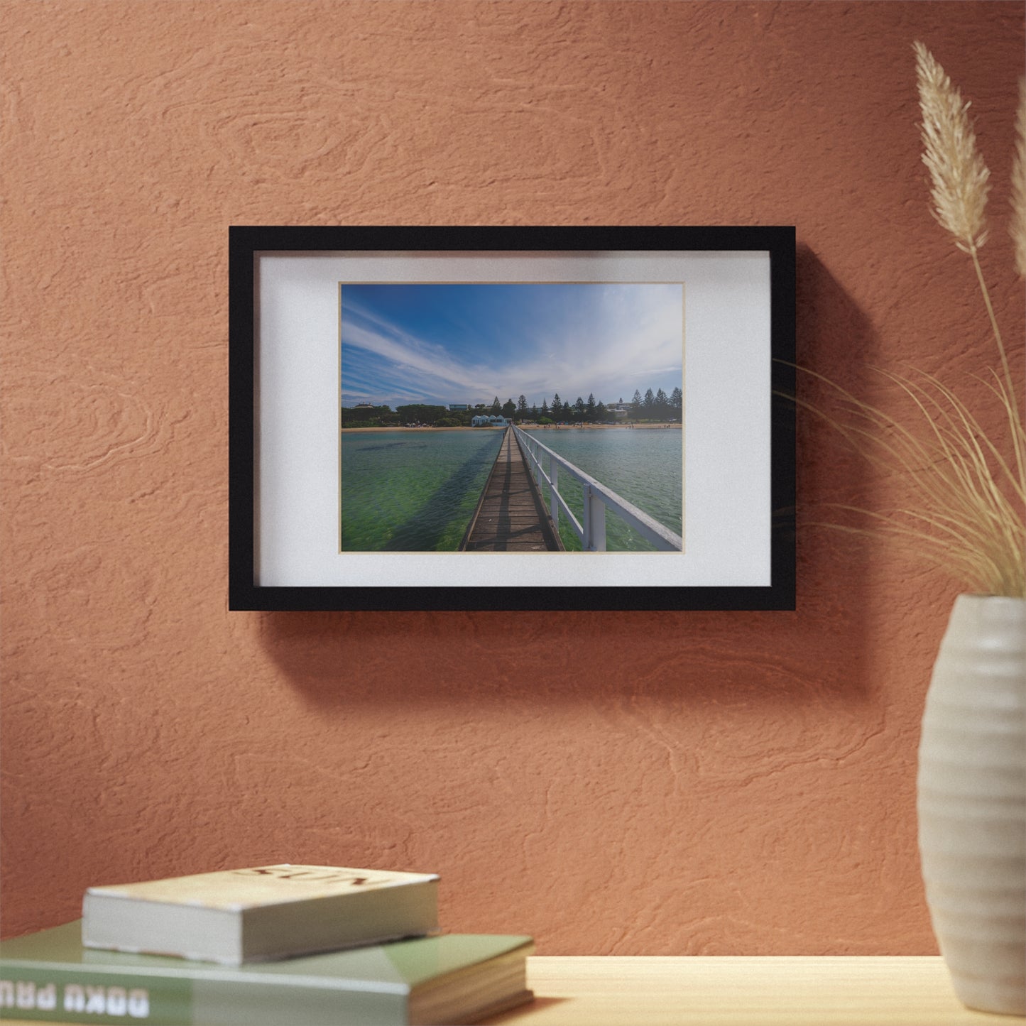 A beautiful jetty leading towards the shore over turquoise waters printed on a black framed poster