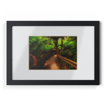 Wooden bridge winding through a lush forest of tall ferns printed black framed poster