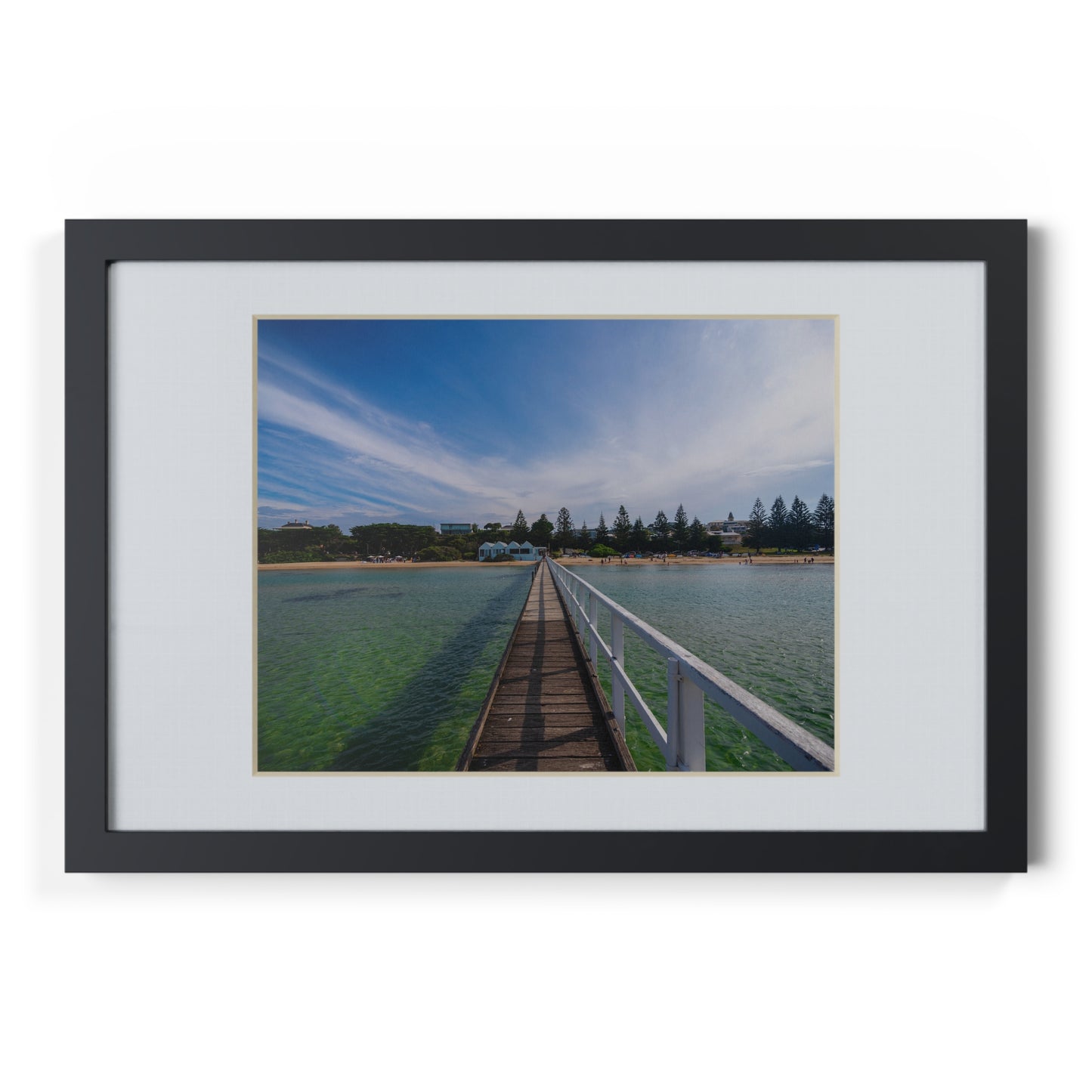 A beautiful jetty leading towards the shore over turquoise waters printed on a black framed poster