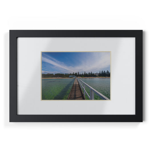 A beautiful jetty leading towards the shore over turquoise waters printed on a black framed poster