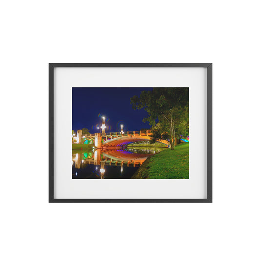 The stunning Victoria Bridge brightly lit at night printed on a framed matte poster