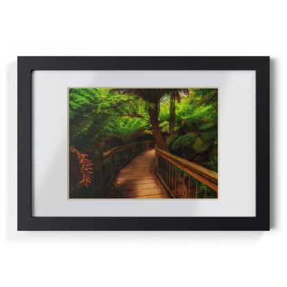 Wooden bridge winding through a lush forest of tall ferns printed black framed poster