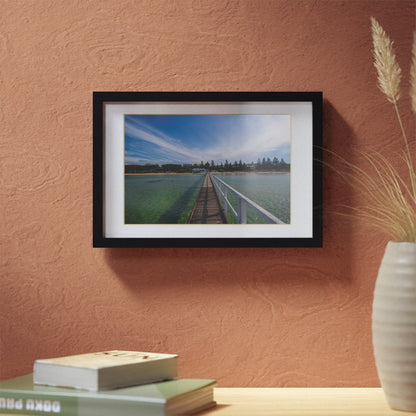 A beautiful jetty leading towards the shore over turquoise waters printed on a black framed poster