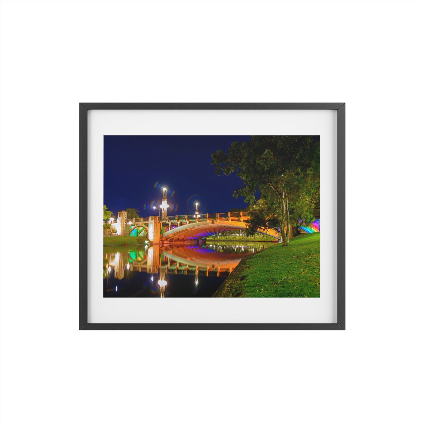 The stunning Victoria Bridge brightly lit at night printed on a framed matte poster