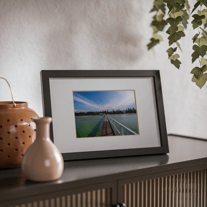 A beautiful jetty leading towards the shore over turquoise waters printed on a black framed poster