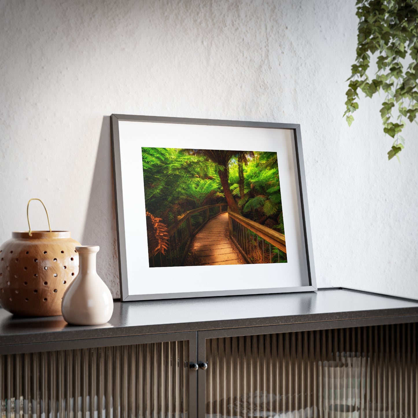 Wooden bridge winding through a lush forest of tall ferns printed on a framed matte poster