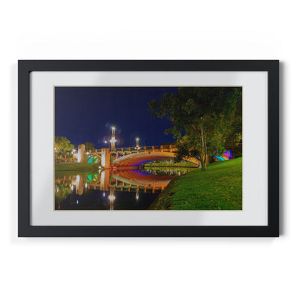 The stunning Victoria Bridge brightly lit at night printed on a black framed poster