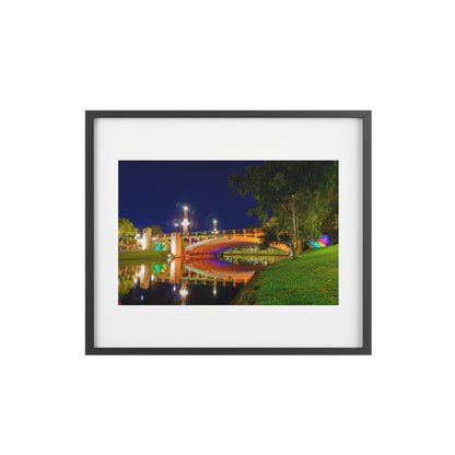 The stunning Victoria Bridge brightly lit at night printed on a framed matte poster