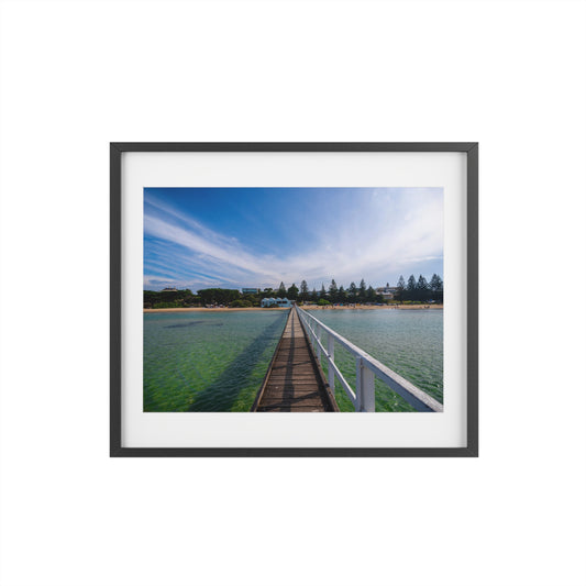 A beautiful jetty leading towards the shore over turquoise waters printed on a matte framed poster