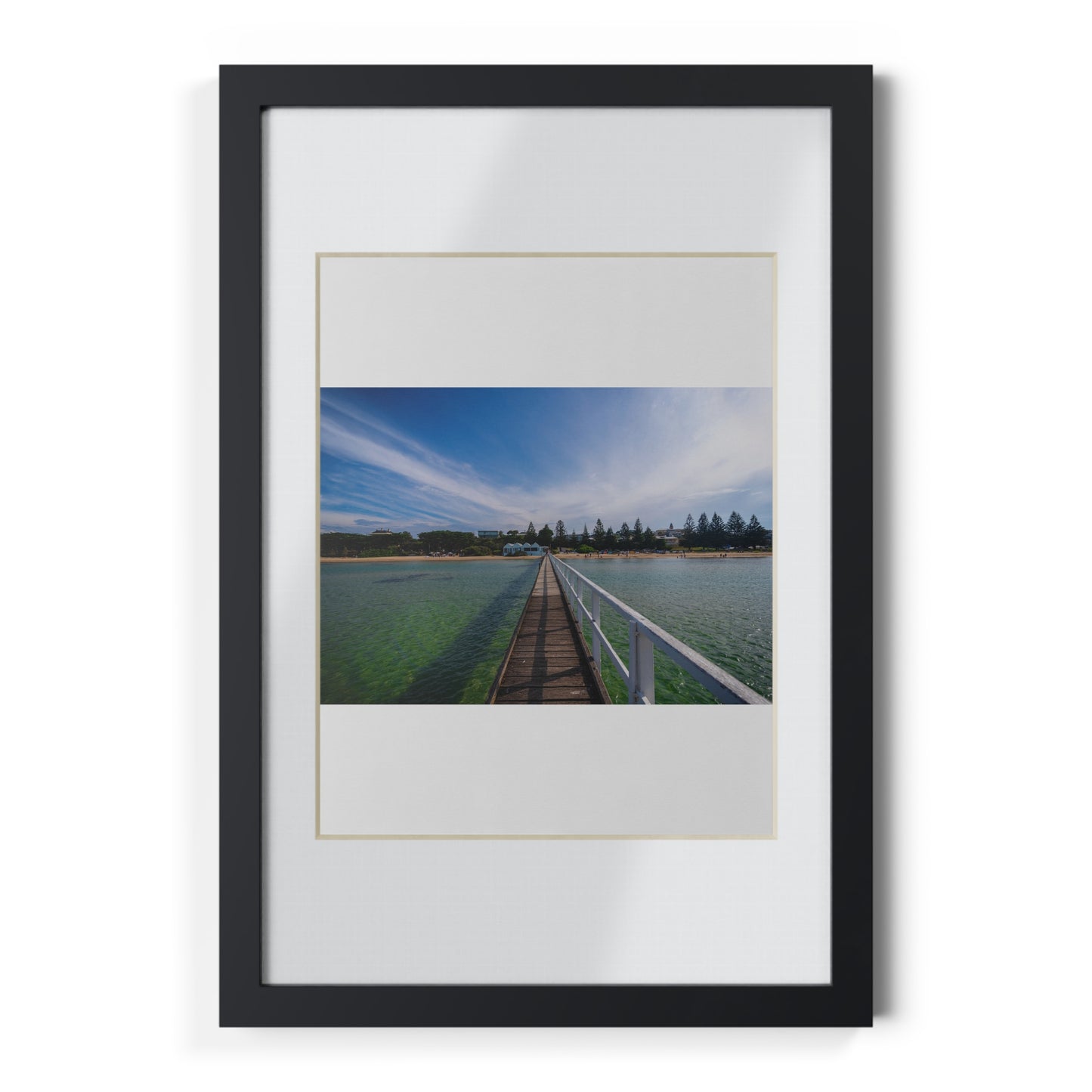 A beautiful jetty leading towards the shore over turquoise waters printed on a black framed poster