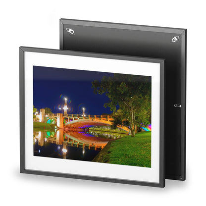 The stunning Victoria Bridge brightly lit at night printed on a framed matte poster