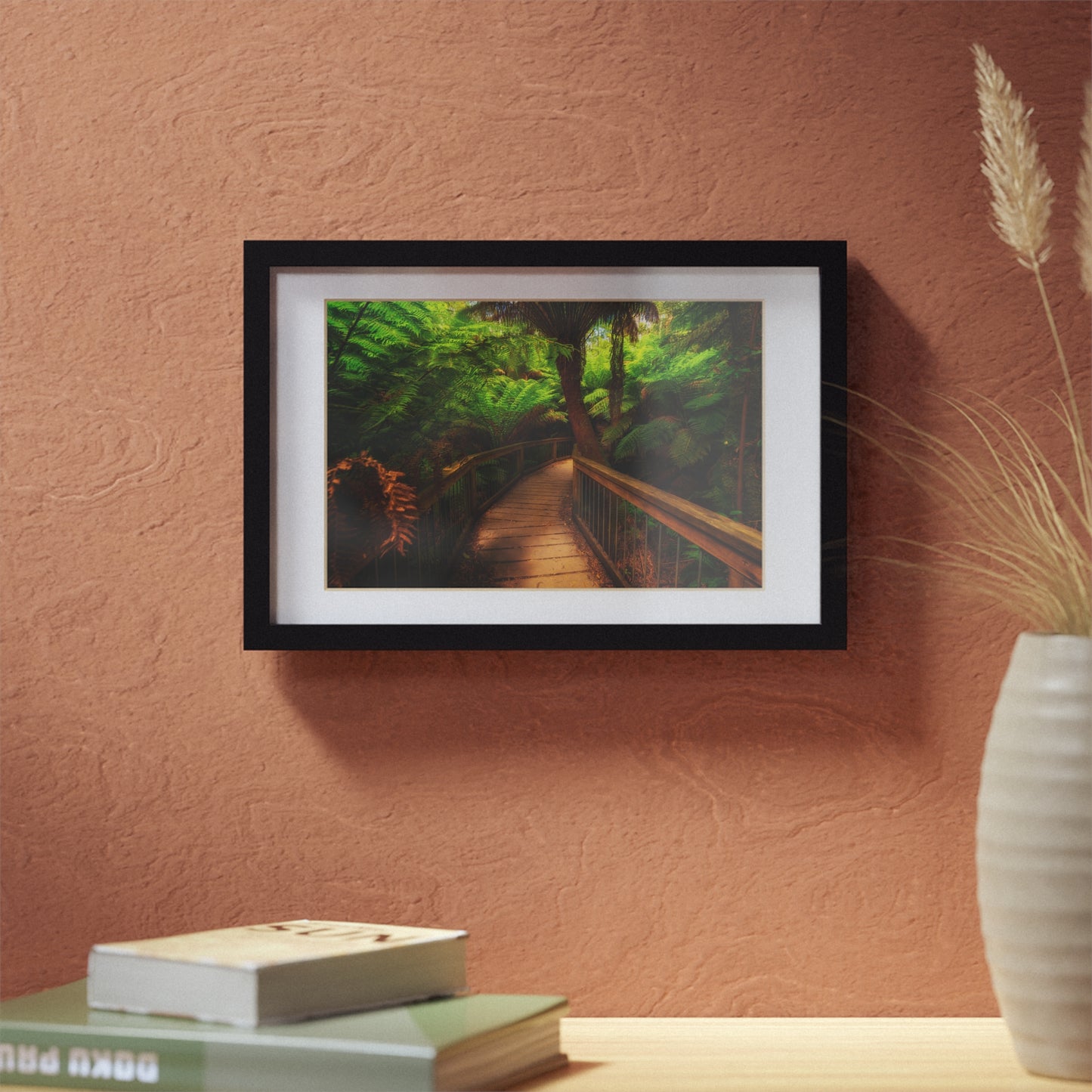 Wooden bridge winding through a lush forest of tall ferns printed black framed poster